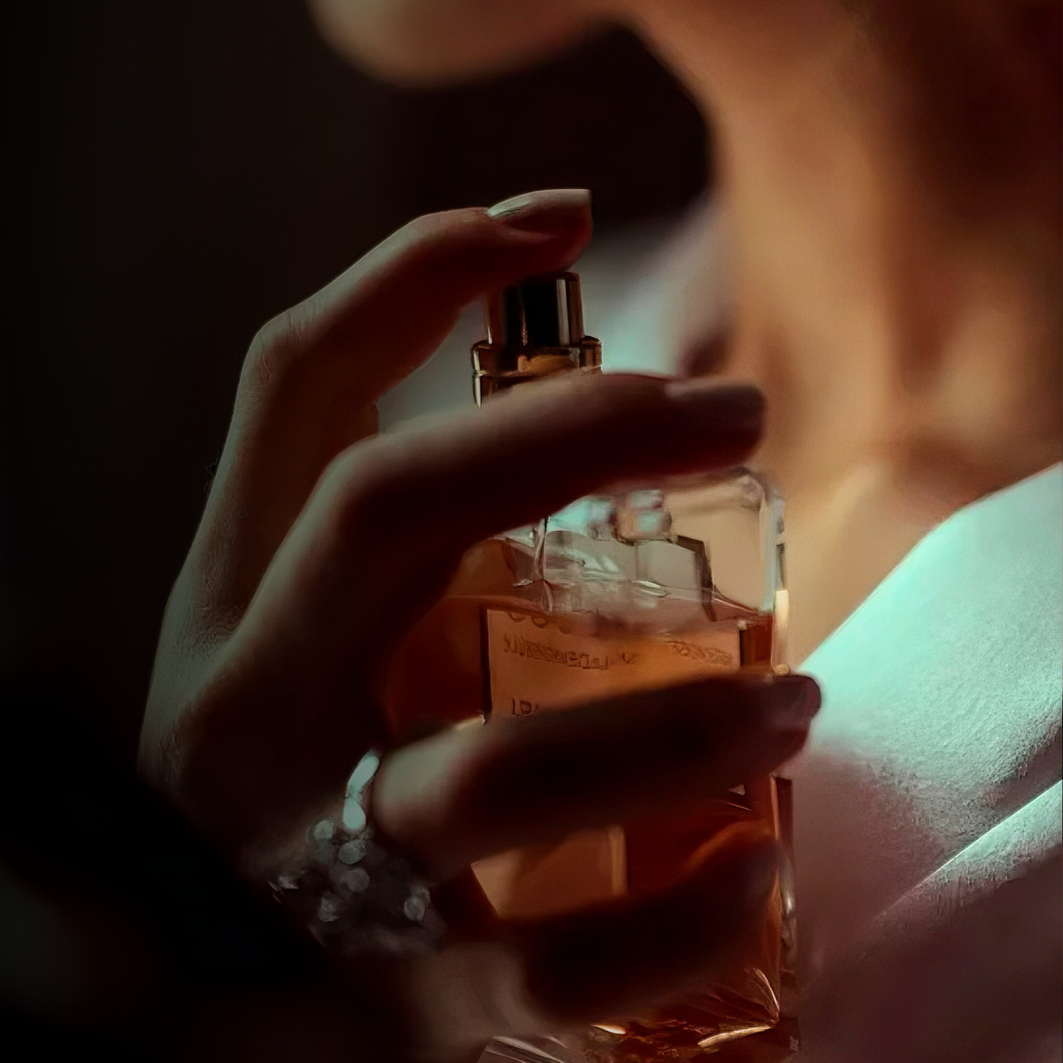 Hand holding a perfume bottle with a warm glow