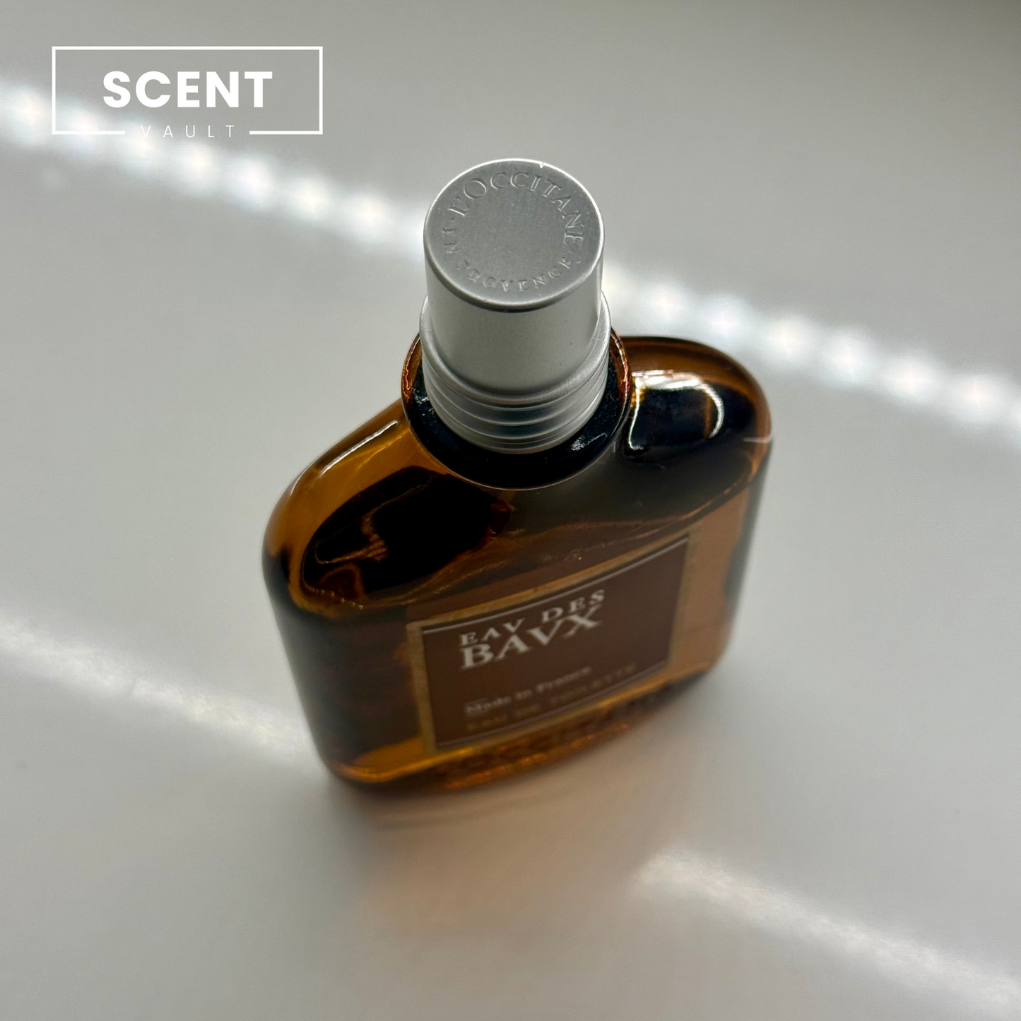 Top view of L'Occitane Eau Des Baux bottle with 2ml, 5ml & 10ml decants. Compact, luxurious, & travel-friendly for affordable premium scent exploration.