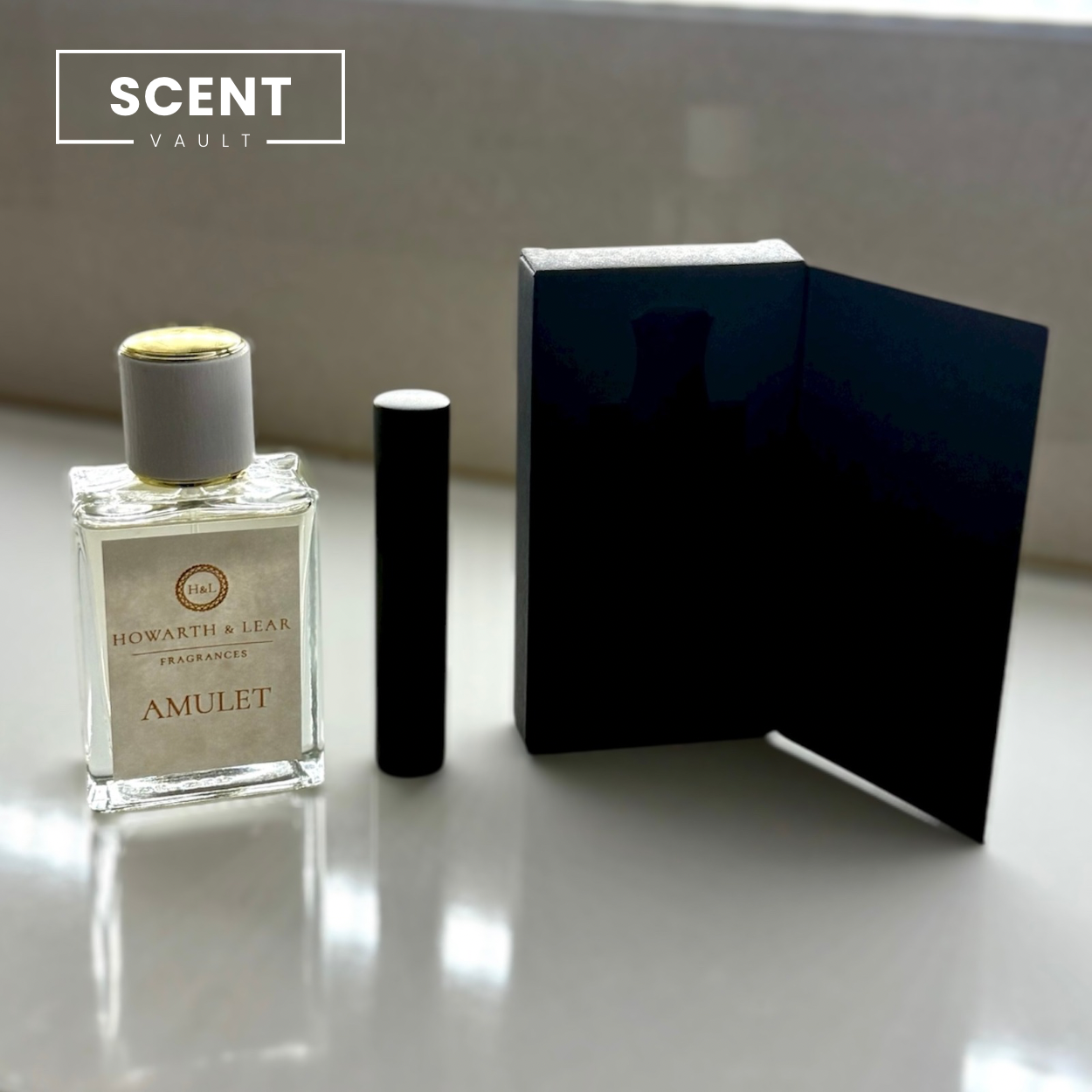 Perfume bottle and black box on a reflective surface with 'SCENT VAULT' branding.