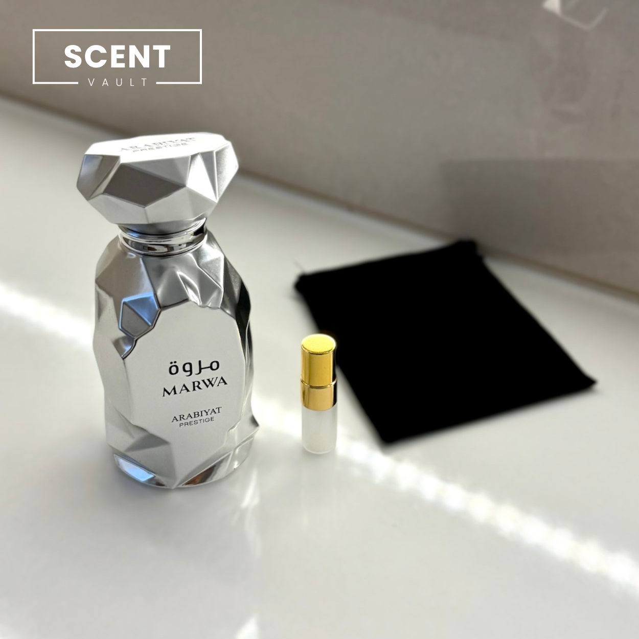 Perfume bottle and luxury 2ml decant bottle on a white surface with 'Scent Vault' branding.