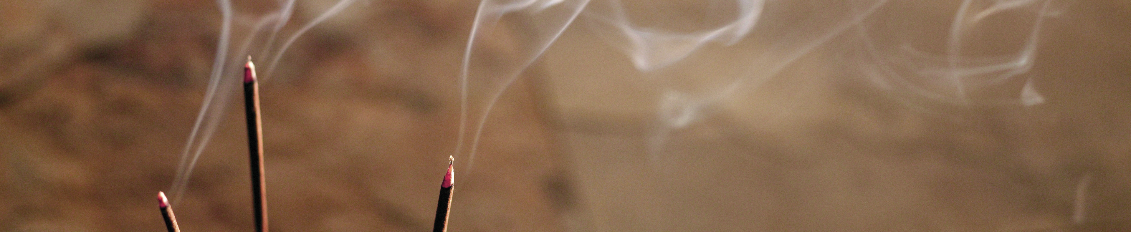 Incense sticks emitting graceful smoke trails, showcasing a calming ambiance and luxury home fragrance experience.