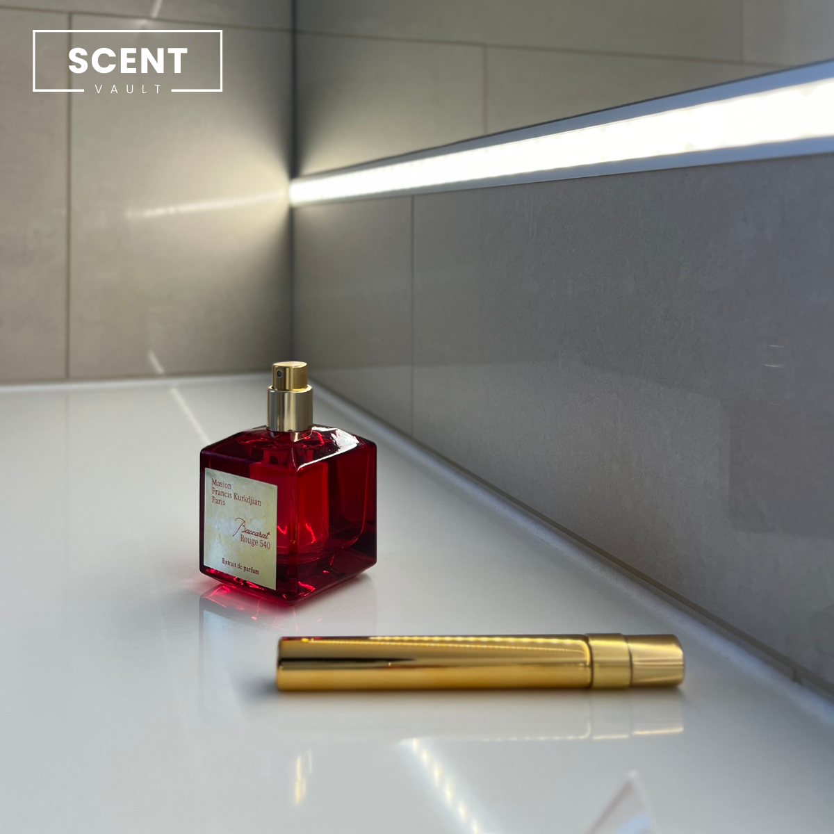 Baccarat Rouge 540 perfume bottle with gold cap and gold decant bottle on a white surface, 'SCENT VAULT' branding visible.