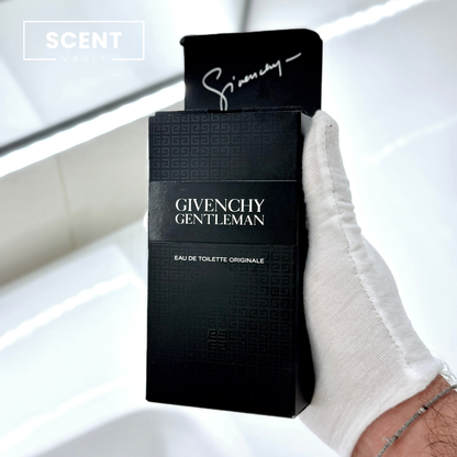 Givenchy Gentleman perfume packaging held by a gloved hand on a white background