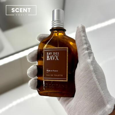 Hand holding a brown Eau Des Bavx perfume bottle with 'Scent Vault' branding.
