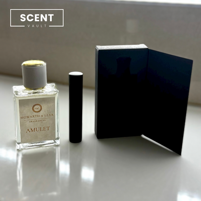 Perfume bottle and black box on a reflective surface with 'SCENT VAULT' branding.