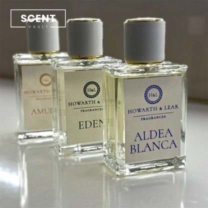 Three Howarth & Lear fragrances bottles labeled 'Amul', 'Eden', and 'Aldea Blanca' on a reflective surface.