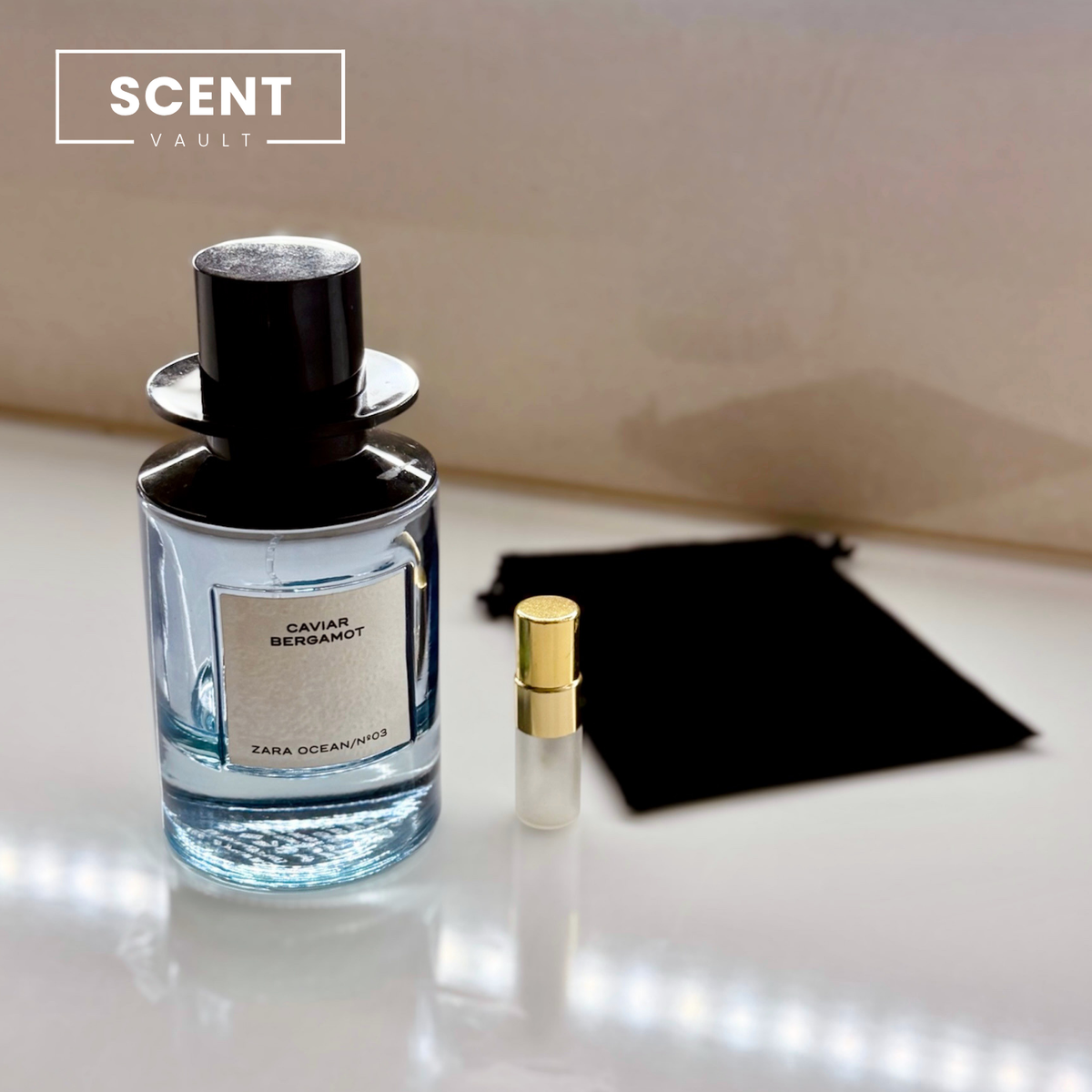 Zara x Jo Malone Caviar Bergamot bottle beside a decant spray vial and black velvet pouch - Scent Vault